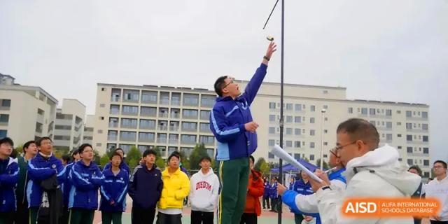 A staff member raises a hand to signal the start of a sports competition at The Guandu Experimental School Affiliated To Shanghai Normal University.