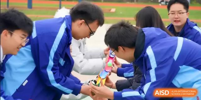 Two students work together on a technical project during an outdoor activity at The Guandu Experimental School Affiliated To Shanghai Normal University.