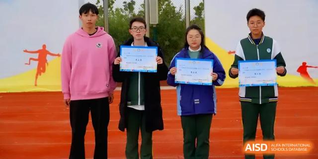 Three students stand together while displaying their achievement certificates at The Guandu Experimental School Affiliated To Shanghai Normal University.