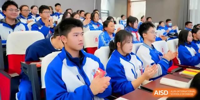 Students in blue and white jackets sit at their desks while focusing on a classroom presentation at The Middle School Affiliated to Sichuan University.