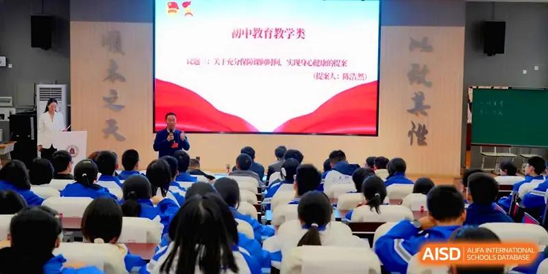 An instructor stands before a seated audience in a lecture hall during an educational seminar at The Middle School Affiliated to Sichuan University.