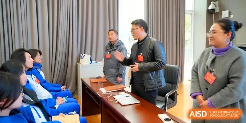 Two staff members engage in a professional discussion at a conference table during a meeting at The Middle School Affiliated to Sichuan University.