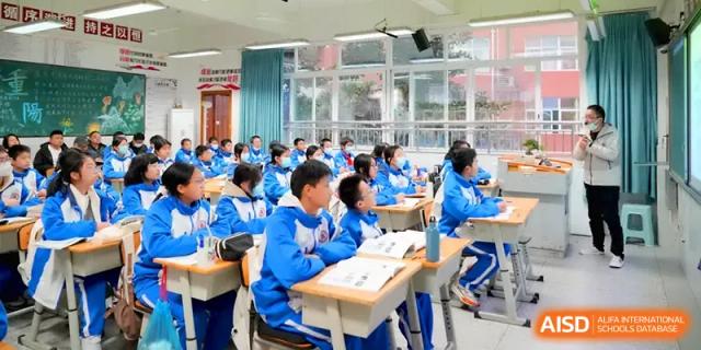 Rows of students in blue uniforms follow along in their textbooks during a morning classroom session at The Middle School Affiliated to Sichuan University.