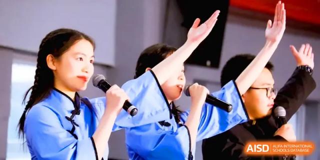 A student in a light blue traditional gown sings passionately into a microphone during a stage performance at The Middle School Affiliated to Sichuan University.