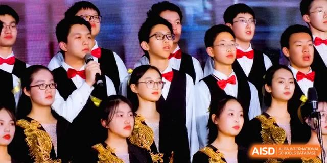 Students in black and gold formal outfits sing together as part of a large school choir during a musical event at The Middle School Affiliated to Sichuan University.