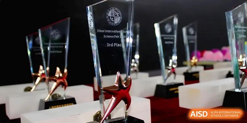 A close-up shot of a clear glass 3rd place trophy for a Science Fair at Xiwai International School.