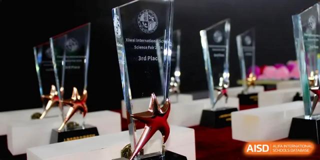 A close-up shot of a clear glass 3rd place trophy for a Science Fair at Xiwai International School.