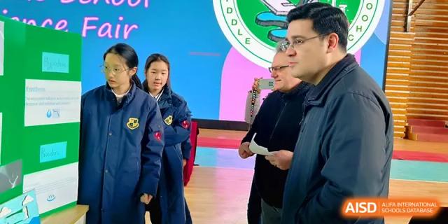 A student talks with a teacher or judge during a presentation at a school event at Xiwai International School.