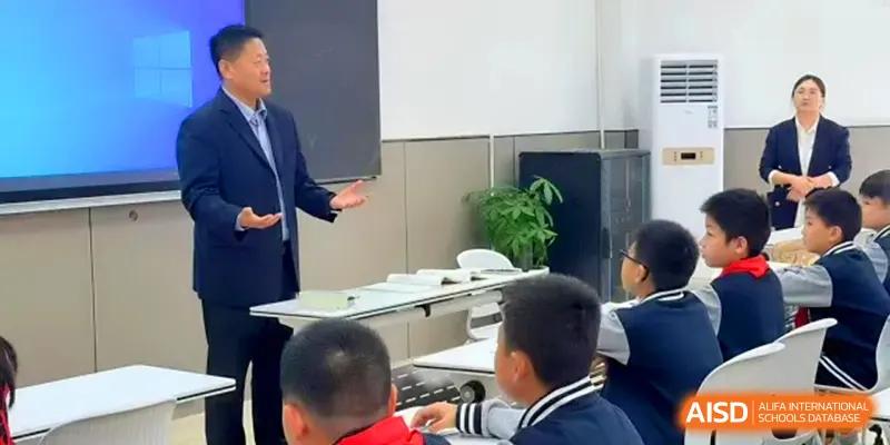 A teacher leads a discussion with a group of students in a modern classroom setting at Xiwai International School.