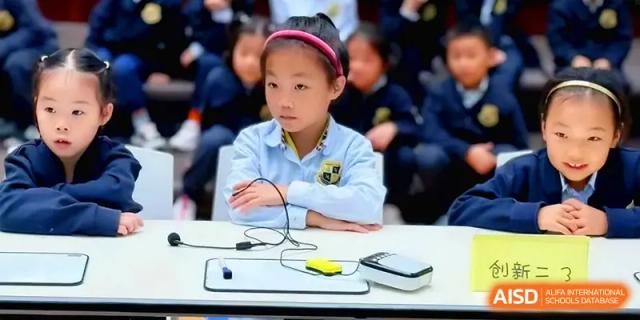A student sits attentively at a desk with science equipment during a classroom activity at Xiwai International School.