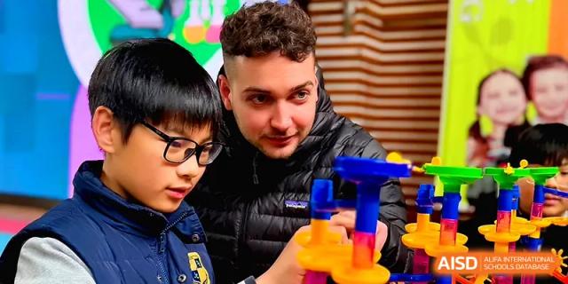 A student and an adult mentor work together on a colorful science experiment at Xiwai International School.