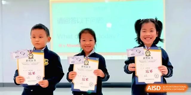 A happy student proudly holds up an award certificate in front of a digital screen at Xiwai International School.