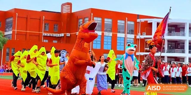 Students and people in dinosaur and frog costumes participate in a lively outdoor parade at Xiwai International School.