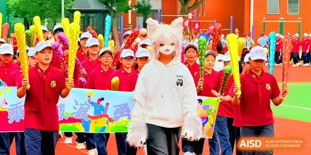 A student wearing a white cat mask and furry gloves leads a colorful parade on the school grounds at Xiwai International School.