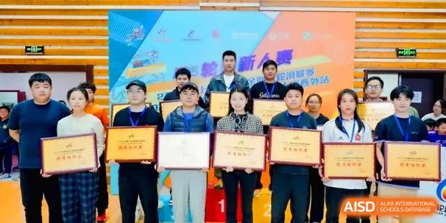 A group of students stands proudly on a podium holding framed award certificates after a competition at Xiwai International School.