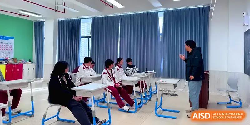 A group of students in matching athletic uniforms sit in a bright classroom during a presentation at Xuzhou No.1 Middle School.