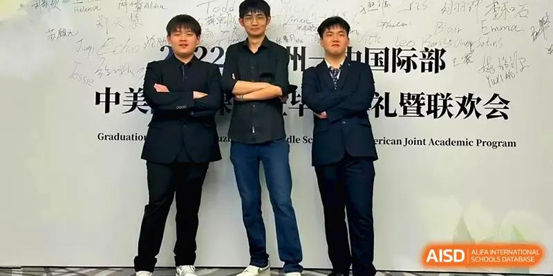 Three young men in smart casual attire pose with their arms crossed in front of a white wall at Xuzhou No.1 Middle School.
