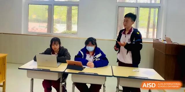 A student stands up to speak during a group discussion while classmates listen at their desks at Xuzhou No.1 Middle School.