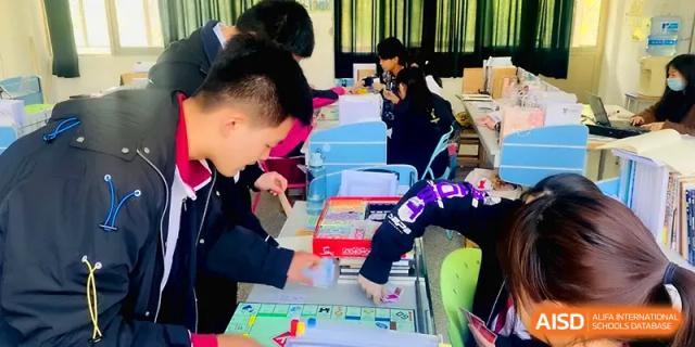 Students work in small groups on a creative project involving colorful materials and diagrams at Xuzhou No.1 Middle School.