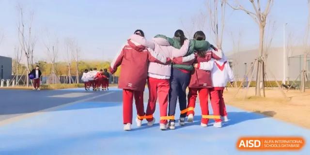 A line of students with their legs tied together works on their synchronization during a race at Xuzhou No.1 Middle School.