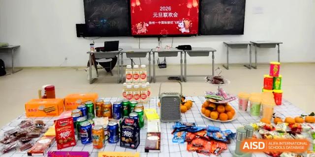 A wide variety of drinks, snacks, and fruit are arranged on a checkered tablecloth for a party at Xuzhou No.1 Middle School.