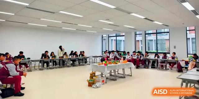 A large, bright classroom is set up with tables of food for a student holiday gathering at Xuzhou No.1 Middle School.