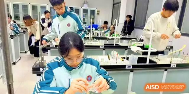 Students work in pairs to conduct a chemistry experiment using glassware in a modern laboratory at Yangzhou High School of Jiangsu Province.
