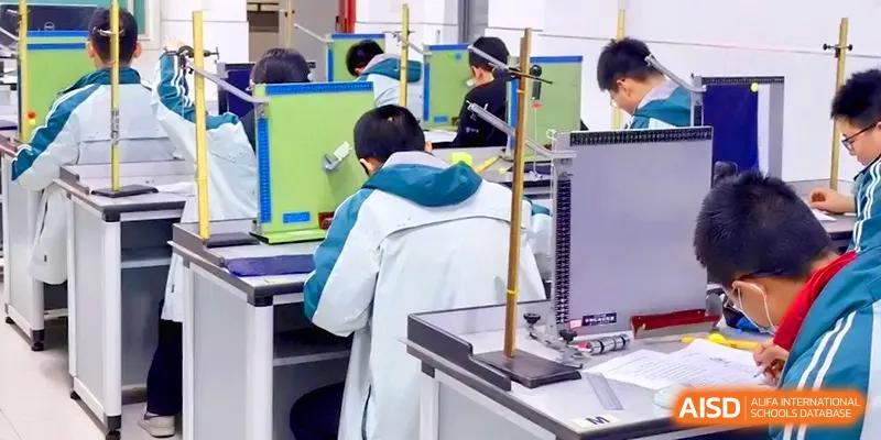 A student in a school uniform focuses on setting up physics equipment during a practical lab session at Yangzhou High School of Jiangsu Province.