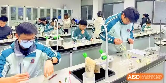 A group of students huddles around a lab station to observe a scientific demonstration at Yangzhou High School of Jiangsu Province.