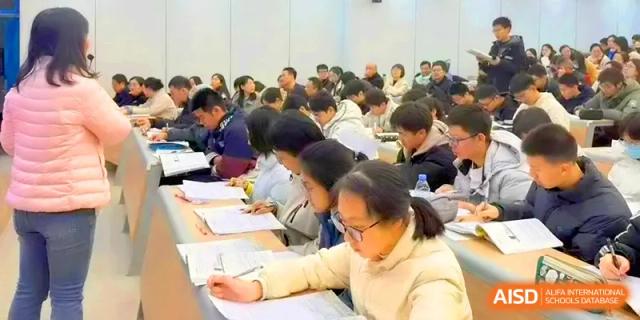 Students sit closely together in a lecture hall, taking detailed notes during an intensive study session at Yangzhou High School of Jiangsu Province.