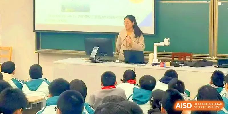 A female teacher stands behind a podium, leading a digital presentation for her class at Yangzhou High School of Jiangsu Province.