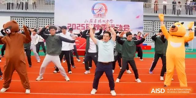 A large group of students performs synchronized exercises on a red track during a sports meet at Yangzhou High School of Jiangsu Province.
