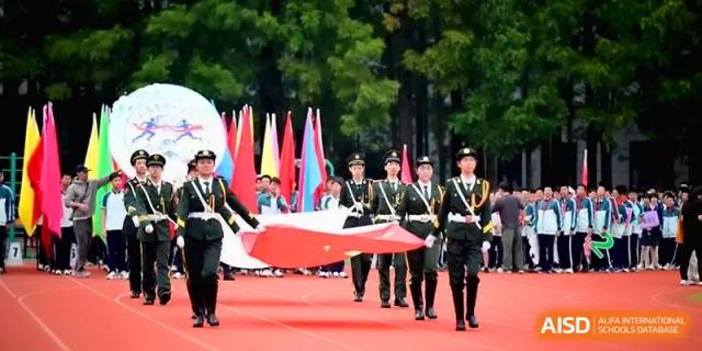 A student color guard team marches solemnly while carrying a large national flag at Yangzhou High School of Jiangsu Province.