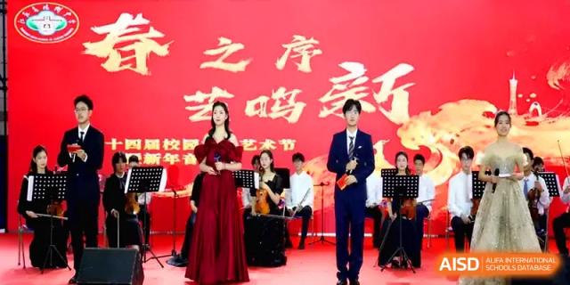 Student hosts and a musical ensemble perform on a bright red stage for a school festival at Yangzhou High School of Jiangsu Province.