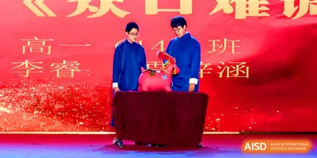 Two students in traditional blue robes perform a cultural ceremony on a stage at Yangzhou High School of Jiangsu Province.