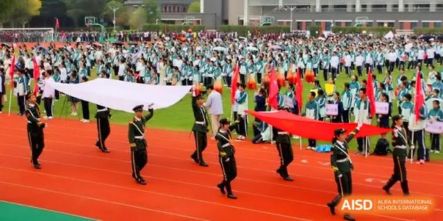 A large-scale outdoor ceremony features student guards and hundreds of participants on a track at Yangzhou High School of Jiangsu Province.