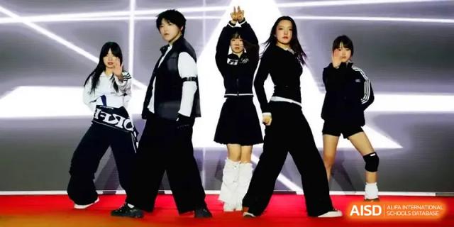 Three students in stylish black and white outfits perform a choreographed dance on stage at Yangzhou High School of Jiangsu Province.