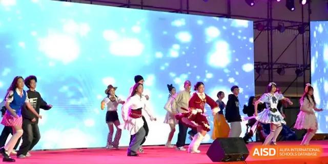 Students in colorful costumes perform a modern dance routine under bright stage lights at Yangzhou High School of Jiangsu Province.