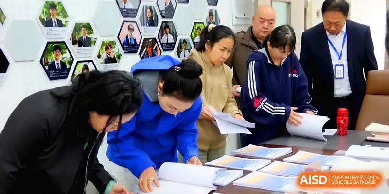 A group of educators and parents examine student portfolios and academic materials during a school event at Beijing Xinxuedao Linchuan School.
