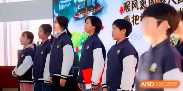Students in navy and white uniforms stand in a row, participating in a formal choir or assembly performance at Beijing Xinxuedao Linchuan School.
