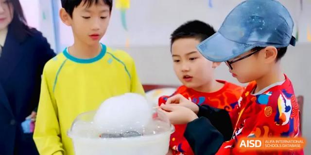 Students gather excitedly around a cotton candy machine to watch the fluffy treat being made at Beijing Xinxuedao Linchuan School.