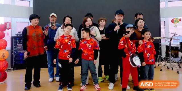 Students and parents participate in a group activity on stage during a lively school community event at Beijing Xinxuedao Linchuan School.