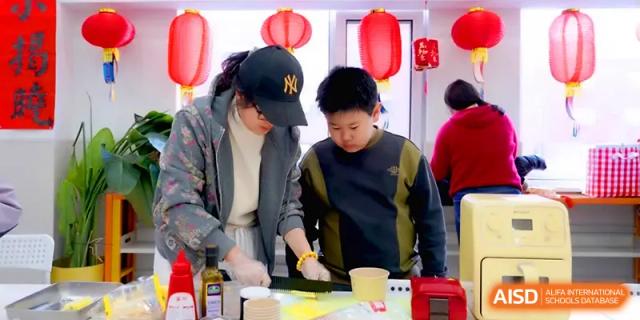 A student learns how to prepare traditional food under the guidance of an instructor at Beijing Xinxuedao Linchuan School.