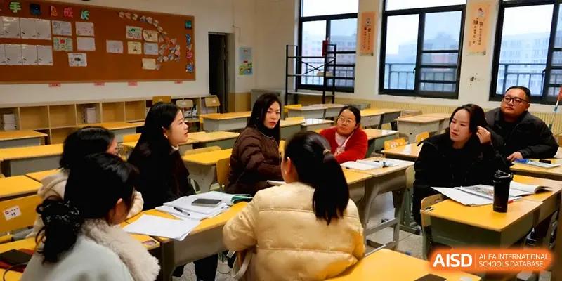 A small group of educators sits together in a classroom to discuss curriculum development and student progress at Changsha Mingda Middle School.