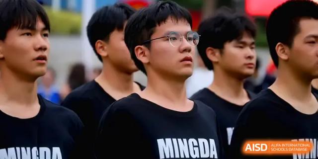 A focused student wearing a black "MINGDA" shirt stands with his peers during a formal school gathering at Changsha Mingda Middle School.