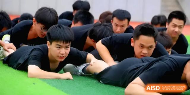 Students demonstrate physical agility and coordination during a challenging team-based exercise on the field at Changsha Mingda Middle School.