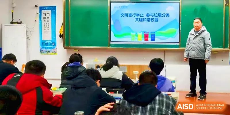 Students sit at their desks while a digital screen displays a colorful lesson on environmental awareness and recycling at Walton-Hefei School.