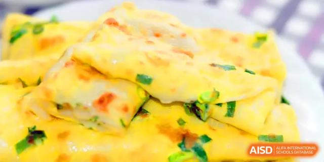 A close-up of freshly prepared scallion pancakes, part of the nutritious and diverse breakfast menu at Walton-Hefei School.