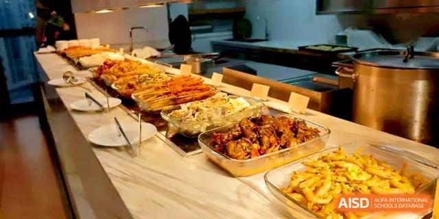 An array of hot, freshly cooked dishes is neatly arranged on the buffet line for the student lunch hour at Walton-Hefei School.