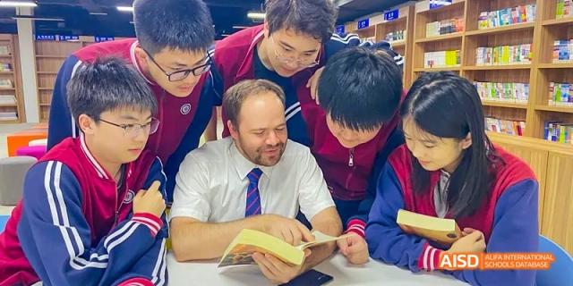 A teacher at Beijing Limai (International) School helps students with an assignment.